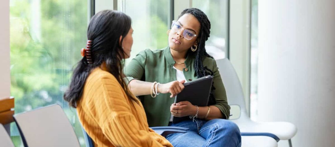 An empathetic female counselor listens as a vulnerable patient shares about a difficult situation.