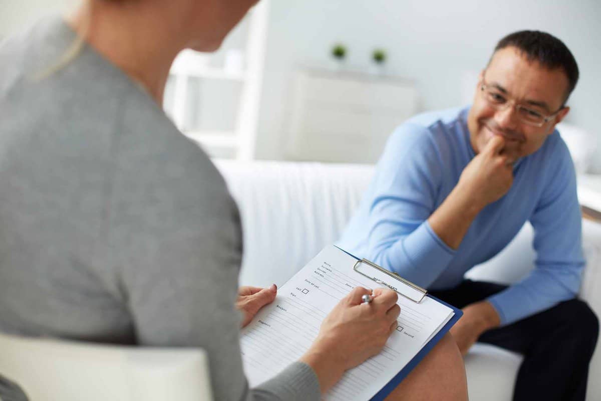 Female psychologist consulting mature man during psychological therapy session