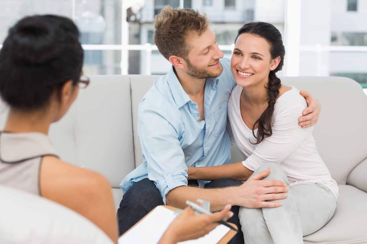 Happy couple reconciling at therapy session in therapists office