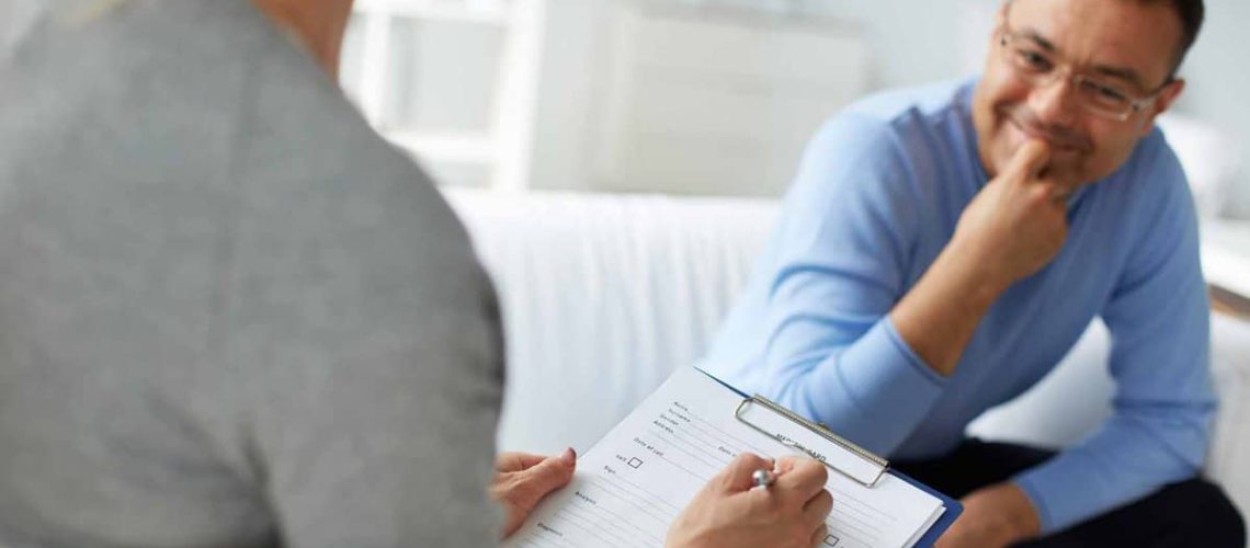 Female psychologist consulting mature man during psychological therapy session