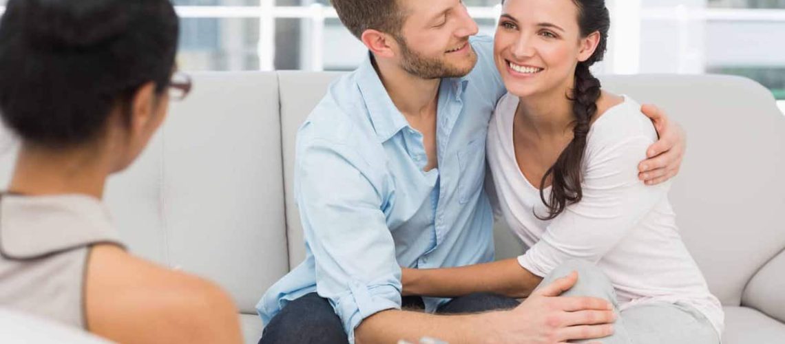 Happy couple reconciling at therapy session in therapists office