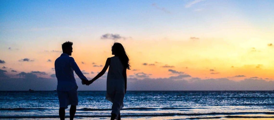 Couples Waling Holding Hands on Beach