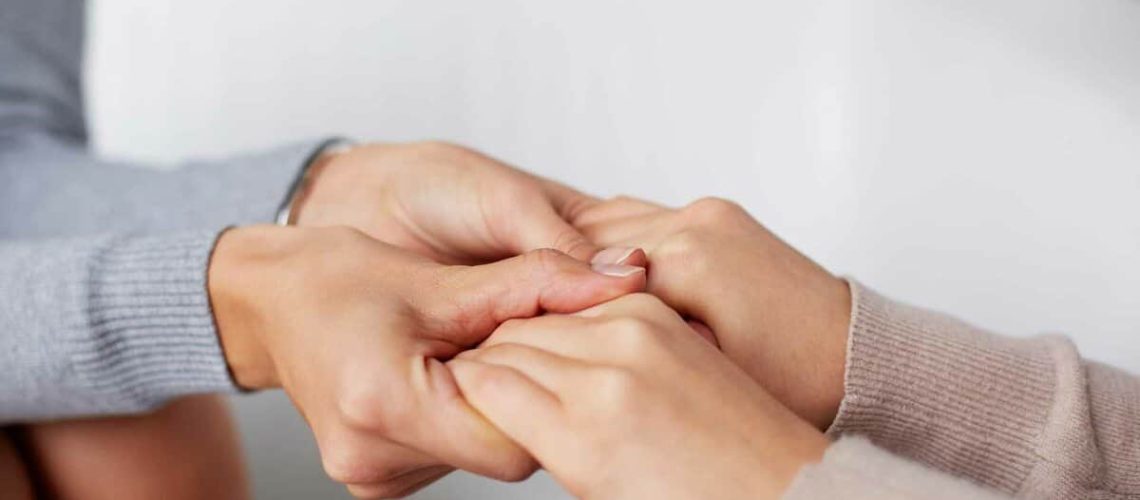 Close-up of psychiatrist hands holding those of her patient