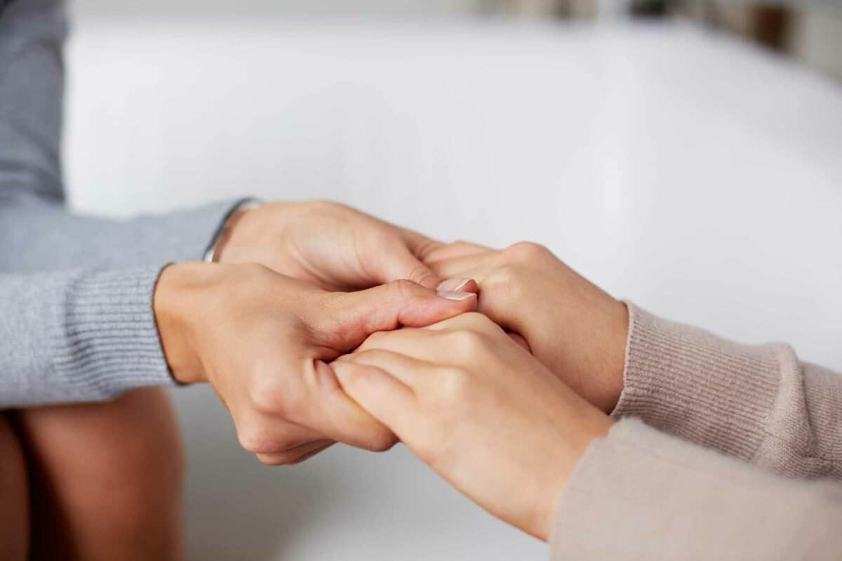 Close-up of psychiatrist hands holding those of her patient